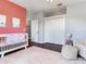 Well-designed Bedroom with a crib, chair, rug, and a unique pink accent wall at 3003 W Leila Ave, Tampa, FL 33611