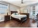 Spacious bedroom features a ceiling fan, dark wood furniture, and a bright window with decorative curtains at 3003 W Leila Ave, Tampa, FL 33611