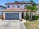 Two-story home with a clay tile roof, arched entryway, and mature landscaping at 3003 W Leila Ave, Tampa, FL 33611