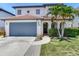 Two-story home with a clay tile roof, arched entryway, and lush landscaping at 3003 W Leila Ave, Tampa, FL 33611