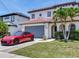Charming two-story home with a clay tile roof, manicured lawn, and a red luxury sports car at 3003 W Leila Ave, Tampa, FL 33611