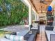 Outdoor living space with a kitchen, seating, play area, and lush landscaping at 3003 W Leila Ave, Tampa, FL 33611