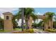 Elegant community entrance features a tiled roof, tall palm trees and flower beds at 311 Kelsey Way # 3, Sun City Center, FL 33573