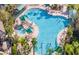 Aerial view of a large community pool with palm trees and green umbrellas at 311 Kelsey Way # 3, Sun City Center, FL 33573