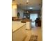 Open-concept kitchen and living space with tile flooring, breakfast bar, and sliding glass doors at 311 Kelsey Way # 3, Sun City Center, FL 33573