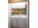 Functional laundry room with white washer and dryer, cabinets, and shelves for ample storage at 311 Kelsey Way # 3, Sun City Center, FL 33573