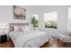 Comfortable bedroom with a gray upholstered bed, soft lighting, and two windows at 3702 54Th W Dr # 104, Bradenton, FL 34210