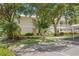 Charming two-story home with a white roof, set amidst lush landscaping and mature trees creating a serene environment at 3702 54Th W Dr # 104, Bradenton, FL 34210