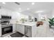 Bright kitchen with stainless steel appliances, sleek white cabinetry, and an open view into the adjacent living space at 3702 54Th W Dr # 104, Bradenton, FL 34210