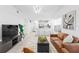 Stylish living room with a tan leather sofa, a modern chandelier, and tile flooring throughout at 3702 54Th W Dr # 104, Bradenton, FL 34210