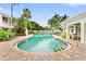Picturesque pool area with tropical plants, trees, loungers, and nearby buildings at 3702 54Th W Dr # 104, Bradenton, FL 34210