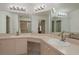 Bright bathroom vanity featuring dual sinks, generous counter space and a large mirror with decorative lighting at 3875 Darston St, Palm Harbor, FL 34685