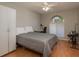 Cozy bedroom with light-colored walls, a ceiling fan, arched window, and practical closet space at 3875 Darston St, Palm Harbor, FL 34685