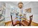 Elegant dining room with a glass table set for a meal, enhanced by an ornate chandelier and bright natural light at 3903 W De Leon St, Tampa, FL 33609