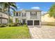 Elegant two-story home with a well-manicured lawn, brick driveway, and inviting curb appeal at 3903 W De Leon St, Tampa, FL 33609