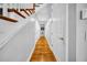 Hallway featuring hardwood flooring, white walls, doors, with a wooden staircase and banister at 3903 W De Leon St, Tampa, FL 33609