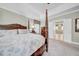 Main bedroom showcasing a decorative four-post bed, neutral carpet and tray ceilings at 3903 W De Leon St, Tampa, FL 33609