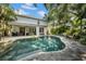Backyard pool view with a lush garden and patio area to relax and enjoy time with Gathering and friends at 3903 W De Leon St, Tampa, FL 33609