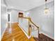 Bright upstairs hallway with hardwood floors and a view of the staircase and dining room below at 3903 W De Leon St, Tampa, FL 33609
