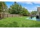 Large backyard with green lawn, wood fence, fire pit, patio set, and grill, great for outdoor living at 4021 Vana Dr, Sarasota, FL 34241