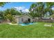 Green backyard featuring a dining set, grill, fire pit, and ample space for outdoor entertaining at 4021 Vana Dr, Sarasota, FL 34241