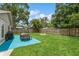 Spacious backyard with a grill, dining set, fire pit, and lush green lawn for outdoor living at 4021 Vana Dr, Sarasota, FL 34241