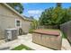 Backyard featuring a hot tub, AC unit, and tropical plants creating a tranquil outdoor space at 4021 Vana Dr, Sarasota, FL 34241