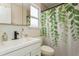 This bathroom features a modern sink, large mirror, and a shower with a leaf-patterned curtain at 4021 Vana Dr, Sarasota, FL 34241