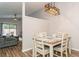 Charming dining area with wood-look floors, modern light fixture, and adjacent open living space at 4021 Vana Dr, Sarasota, FL 34241