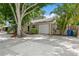 Home featuring a concrete driveway, attached single car garage, and lush landscaping at 4021 Vana Dr, Sarasota, FL 34241