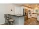 Open kitchen featuring granite countertop bar with seating and stainless steel refrigerator at 4021 Vana Dr, Sarasota, FL 34241