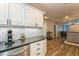 Kitchen featuring white cabinets, dark countertops, and wood-look flooring at 4021 Vana Dr, Sarasota, FL 34241