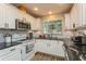 Kitchen with white cabinets, subway tile backsplash, and stainless steel microwave at 4021 Vana Dr, Sarasota, FL 34241