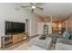 Comfortable living room with vaulted ceiling, ceiling fan, wood-look floors, and entertainment center at 4021 Vana Dr, Sarasota, FL 34241