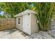 Backyard shed nestled amongst palm trees with a window, door, and AC unit at 4021 Vana Dr, Sarasota, FL 34241