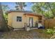 Back of house with backyard featuring exterior storage and foliage with a small porch at 4412 Bray Rd, Tampa, FL 33634