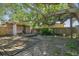 Backyard featuring a shed, a large mature tree, and a wooden deck, surrounded by a wooden fence at 4412 Bray Rd, Tampa, FL 33634