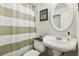 Traditional-style bathroom with a pedestal sink, oval mirror, and shower with green and white striped curtain at 4412 Bray Rd, Tampa, FL 33634