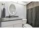 Modern bathroom features a dark granite sink and a black shower curtain at 4412 Bray Rd, Tampa, FL 33634