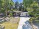 Exterior view of the home showcasing the front yard, driveway, and well-maintained landscaping at 4412 Bray Rd, Tampa, FL 33634