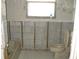 Bathroom with a tub, toilet, patterned wallpaper, and in-progress framing at 4673 Dewey Dr, New Port Richey, FL 34652