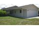 A single-story home with a white exterior, green lawn, and an attached two-car garage at 4673 Dewey Dr, New Port Richey, FL 34652