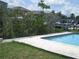 Relaxing in-ground pool surrounded by lush greenery, in a waterfront setting at 4673 Dewey Dr, New Port Richey, FL 34652