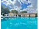 Community pool on a sunny day with lounge chairs and a clubhouse at 501 E Bay Dr # 3504, Largo, FL 33770