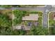 Aerial view of a property with a driveway, lush trees, and a well-maintained lawn at 502 Lincoln Ave, Tarpon Springs, FL 34689