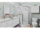 Bathroom featuring a glass corner shower, white toilet, and a double sink vanity with decorative tile backsplash at 502 Lincoln Ave, Tarpon Springs, FL 34689