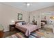 Bright bedroom features colorful rug, ceiling fan, closet with mirrored sliding doors, and en-suite laundry area at 502 Lincoln Ave, Tarpon Springs, FL 34689