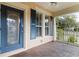 Inviting front porch with blue trim, ceiling fan, and a view of the neighborhood at 502 Lincoln Ave, Tarpon Springs, FL 34689