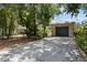 Exterior view of the garage with a spacious driveway and lush landscaping at 502 Lincoln Ave, Tarpon Springs, FL 34689