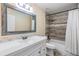 Well-lit bathroom with tiled shower and decorative mirror at 507 4Th Sw Ave, Largo, FL 33770
